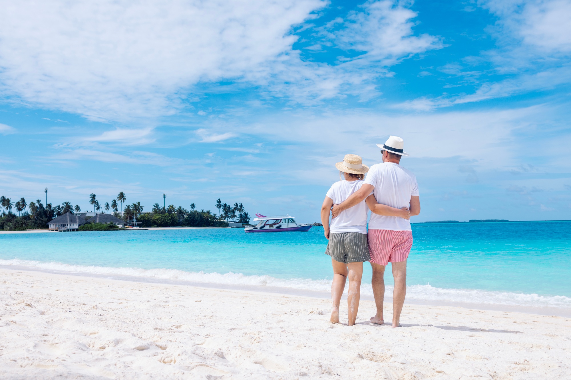 Close-up of young married couple in shorts on ocean shore